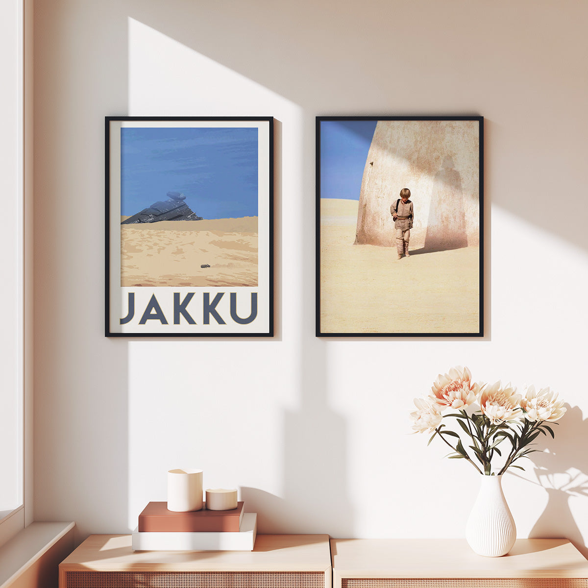 Two framed posters of Naboo and Bespin on a wall, with a vase of flowers on a table below.