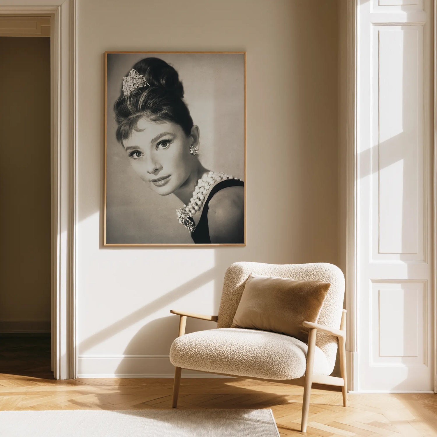 Living room with a framed portrait of a woman on the wall and a cushioned chair.