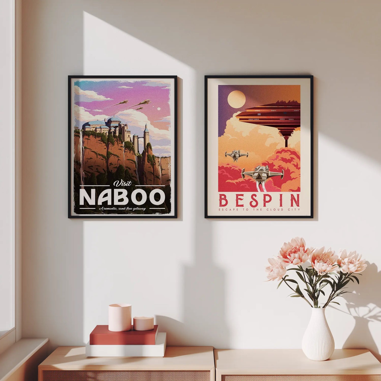 Two framed posters of Naboo and Bespin on a wall, with a vase of flowers on a table below.
